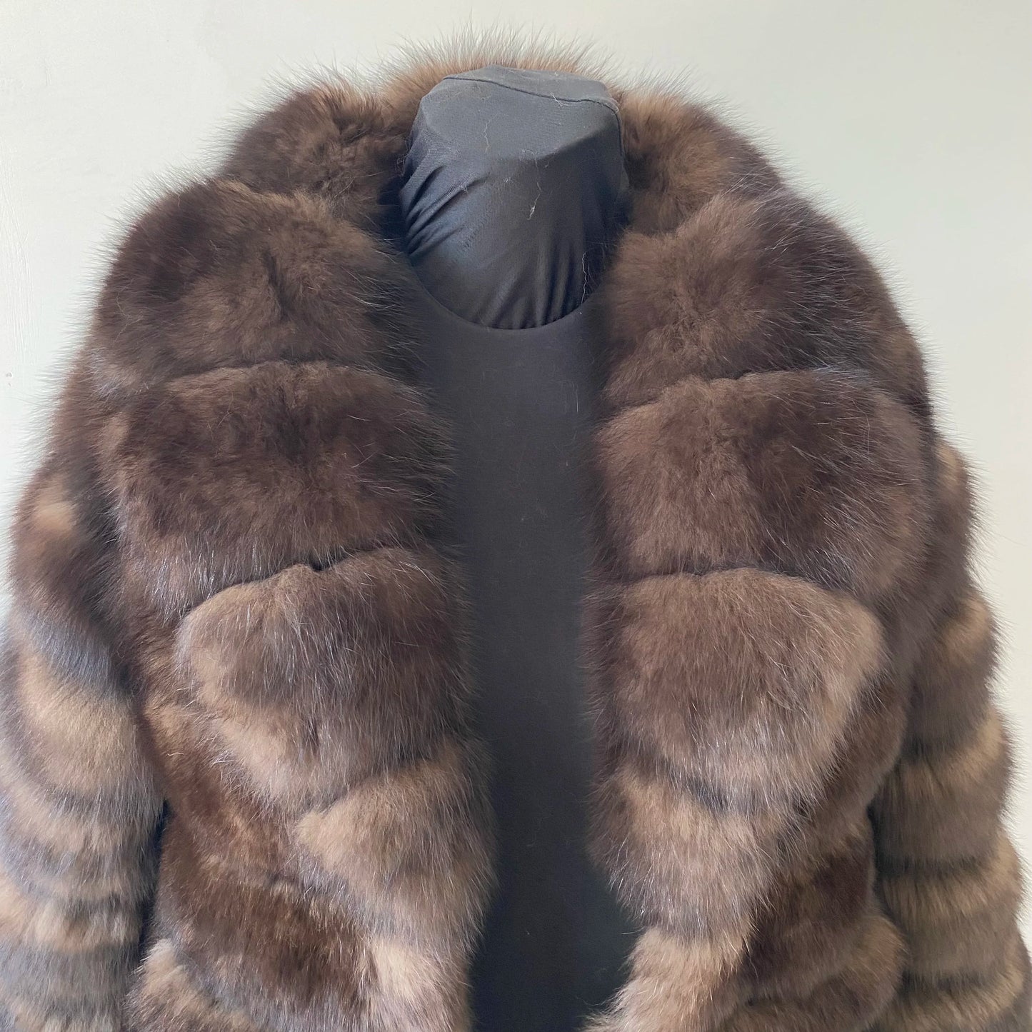 Lady's fashionable warm natural fur coat with a collar for warmth, luxurious high street outerwear