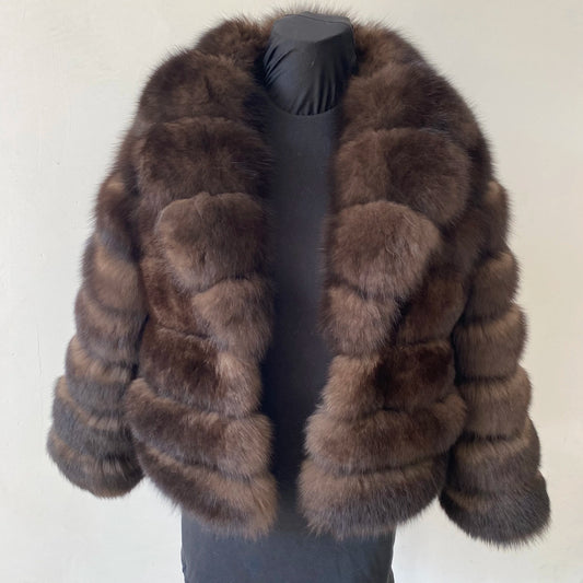 Lady's fashionable warm natural fur coat with a collar for warmth, luxurious high street outerwear
